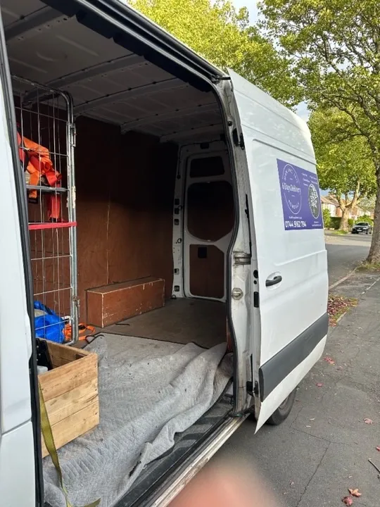 6 Days Logistics branded removals van with side door open, moving blankets laid out and equipment ready for a professional house removal