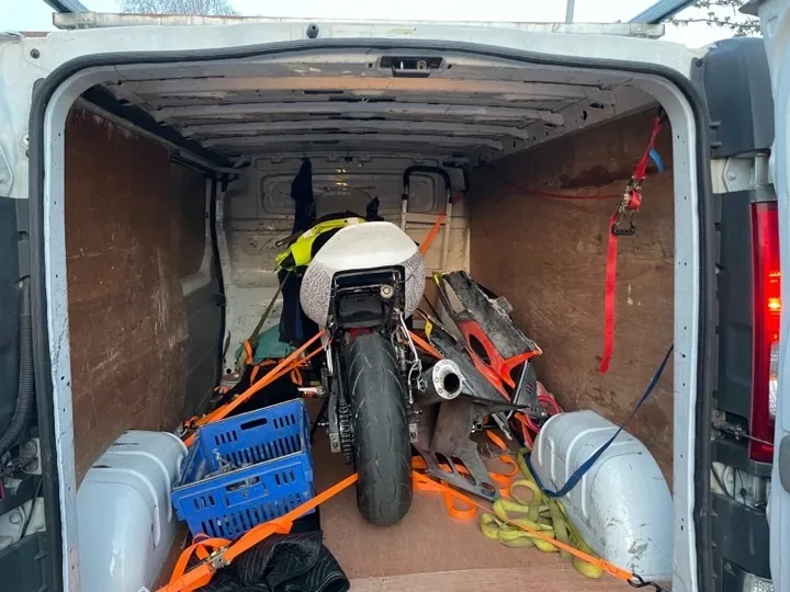 Motorcycle secured with ratchet straps inside a man and van removals vehicle for specialist UK motorcycle transport