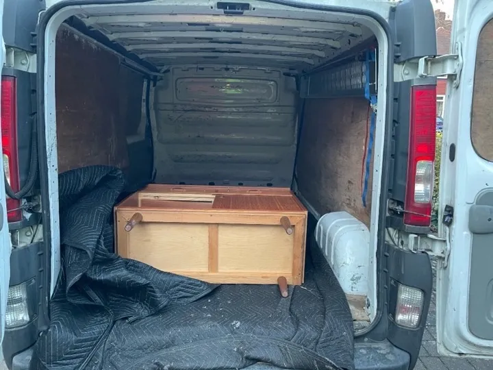 Mid-century sideboard loaded on moving blankets inside a removals van for a single-item small-move furniture delivery